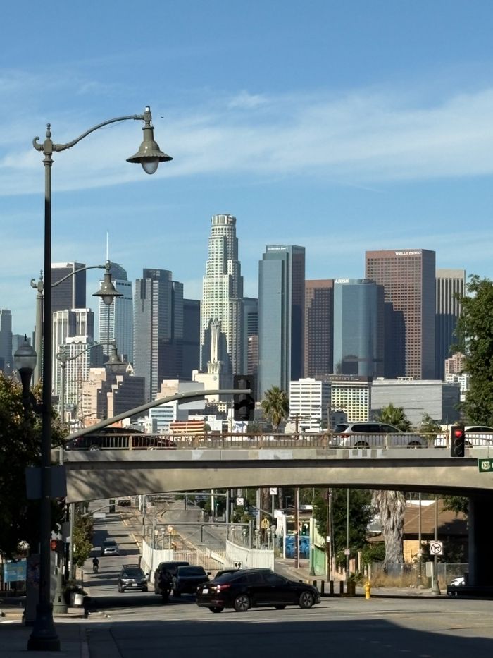 Home Scenic view of downtown Los Angeles skyline under a clear blue sky.